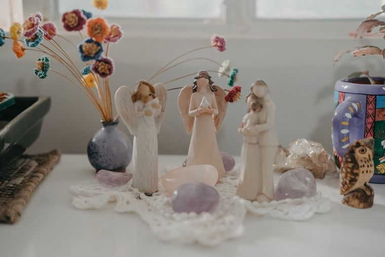Altar com anjos, cristais e flores, num ambiente de luz suave